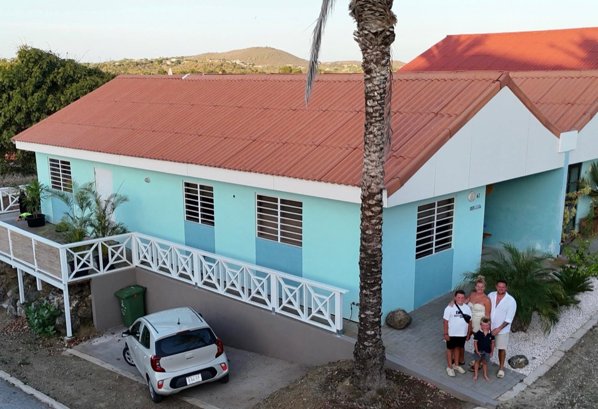 Mike en Nicky met hun kinderen voor hun woning op Curaçao